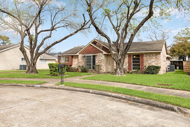 single story home with brick siding, a front lawn, central AC, and a shingled roof