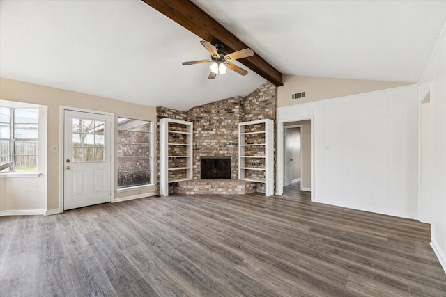 unfurnished living room with visible vents, a ceiling fan, lofted ceiling with beams, wood finished floors, and a brick fireplace