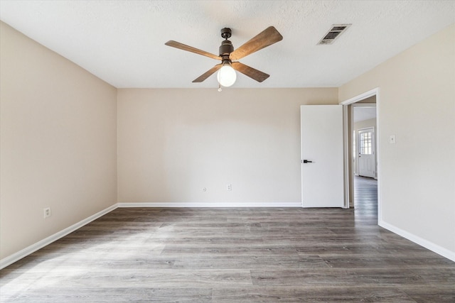 unfurnished room featuring visible vents, a ceiling fan, a textured ceiling, wood finished floors, and baseboards