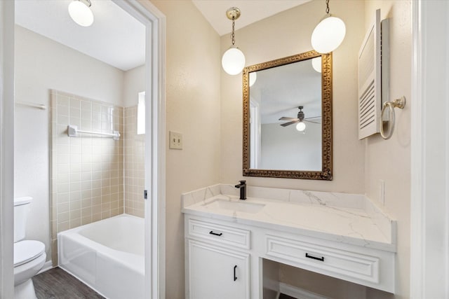 bathroom featuring vanity, bathing tub / shower combination, toilet, and wood finished floors