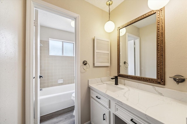 bathroom with radiator, toilet, vanity, wood finished floors, and washtub / shower combination