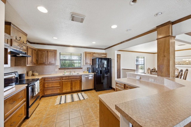 kitchen with light tile patterned flooring, stainless steel appliances, a sink, visible vents, and brown cabinetry