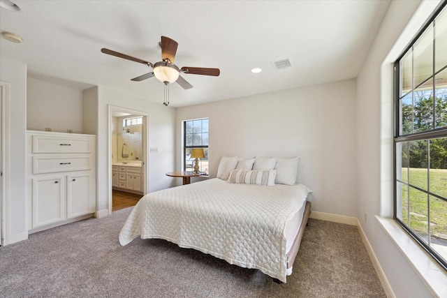 carpeted bedroom with ceiling fan, recessed lighting, visible vents, baseboards, and ensuite bath