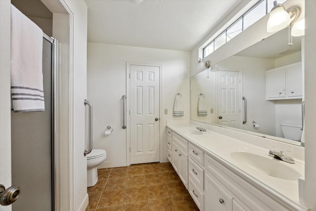 bathroom with toilet, tile patterned flooring, and a sink