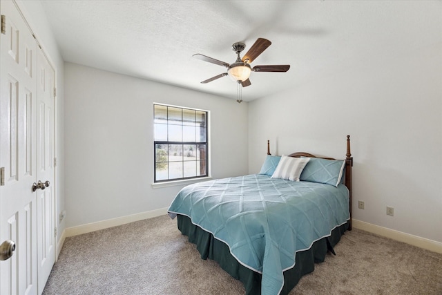 carpeted bedroom with a ceiling fan, a closet, a textured ceiling, and baseboards