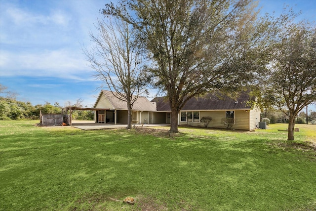 rear view of house with an attached carport, a patio, and a yard