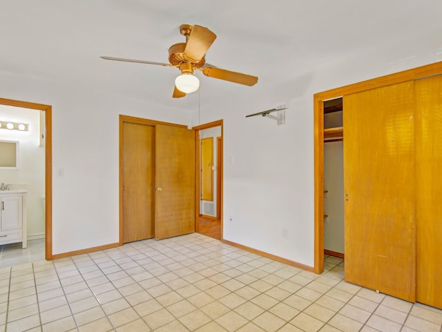 unfurnished bedroom with connected bathroom, baseboards, a closet, and light tile patterned flooring