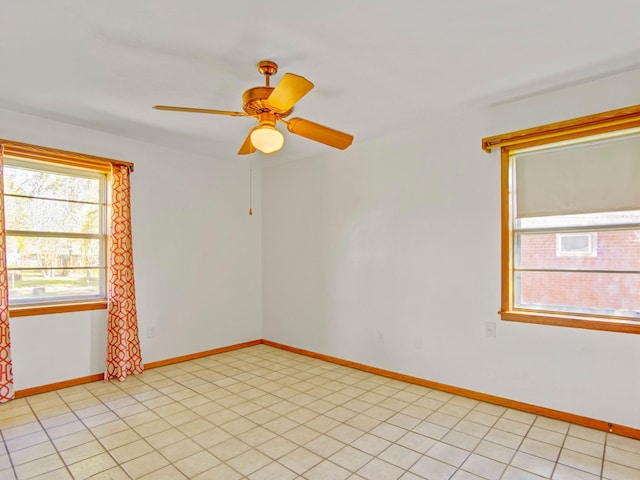 unfurnished room with baseboards, a ceiling fan, and light tile patterned flooring