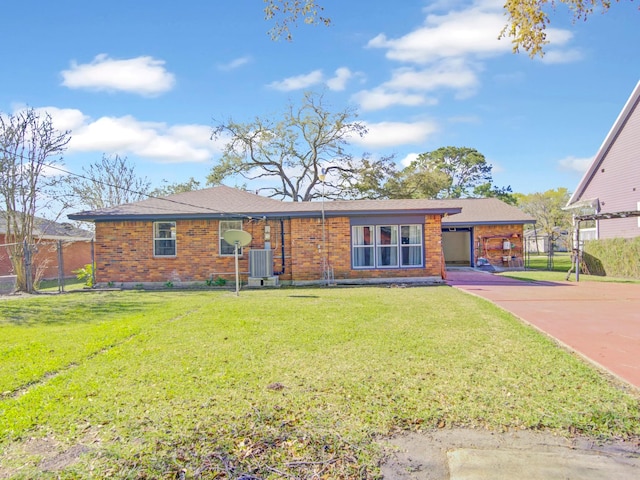 view of front of house with a front yard, concrete driveway, brick siding, and central AC unit