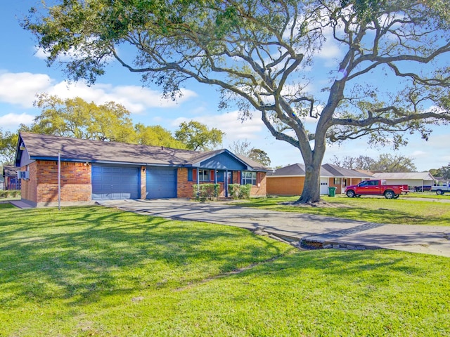 view of front of home featuring driveway, an attached garage, a front lawn, and brick siding