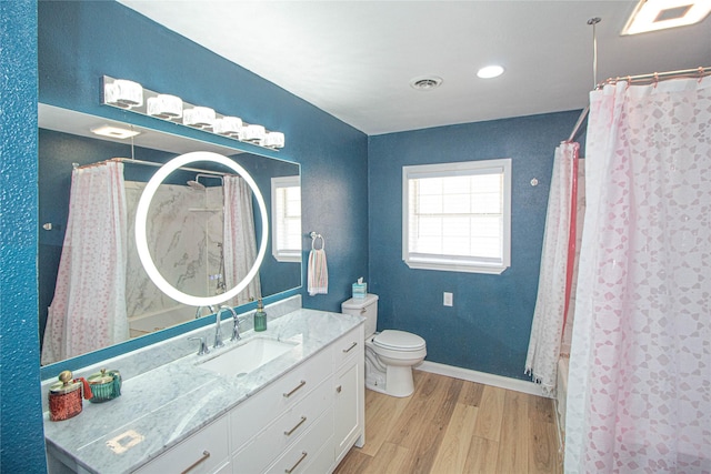 bathroom featuring baseboards, visible vents, a shower with shower curtain, toilet, and wood finished floors