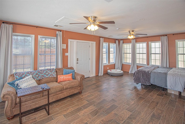 bedroom with dark wood-style floors, attic access, visible vents, and a ceiling fan