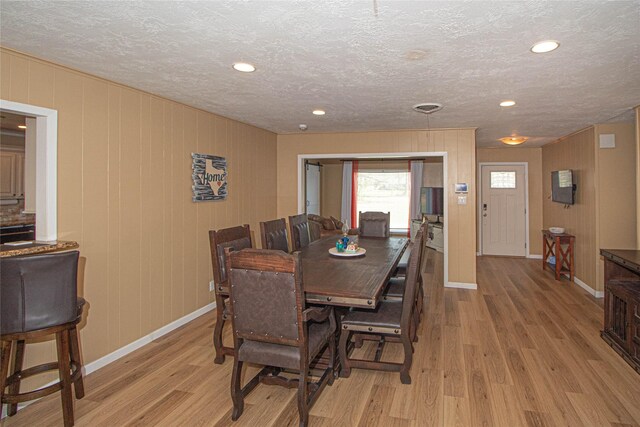 dining area with recessed lighting, light wood-style flooring, baseboards, and a textured ceiling