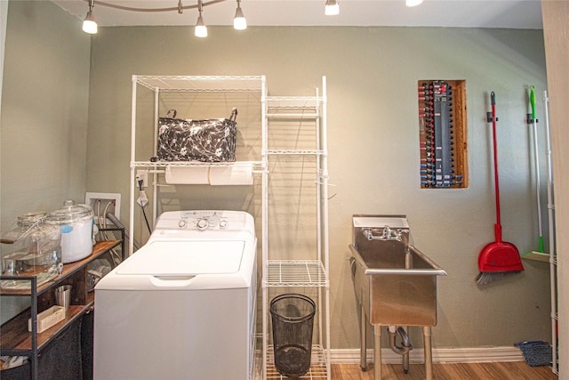 washroom with washer / dryer, laundry area, baseboards, wood finished floors, and a sink