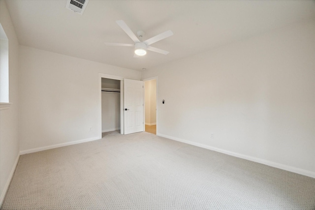 unfurnished bedroom with baseboards, visible vents, a closet, and light colored carpet