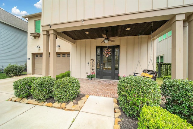 entrance to property featuring driveway, a ceiling fan, french doors, board and batten siding, and an attached garage