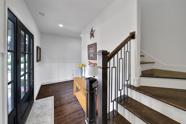 foyer with visible vents, dark wood-type flooring, recessed lighting, wainscoting, and a decorative wall