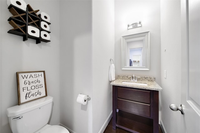 bathroom with vanity, toilet, and baseboards