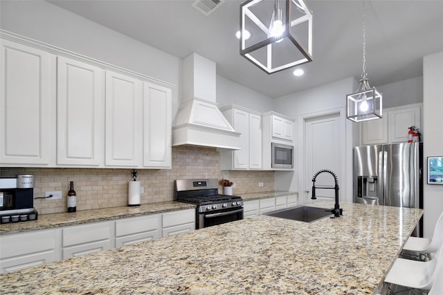 kitchen featuring visible vents, custom exhaust hood, a sink, appliances with stainless steel finishes, and tasteful backsplash