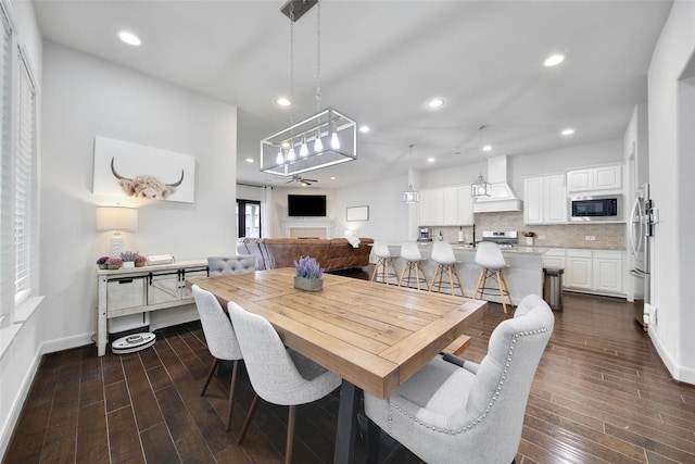 dining area featuring dark wood finished floors, recessed lighting, and baseboards