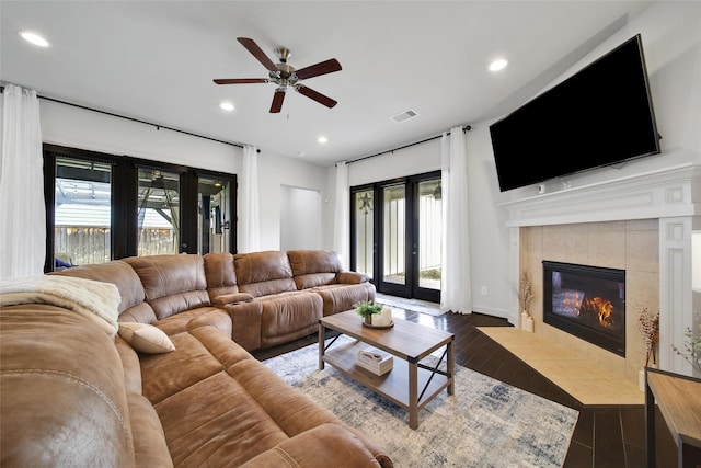 living area with a fireplace, recessed lighting, wood finished floors, and visible vents