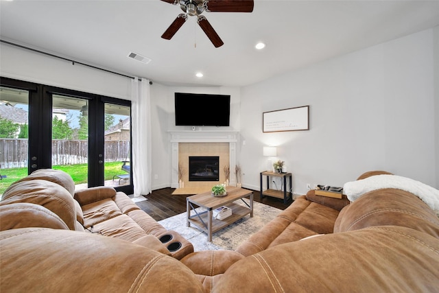 living area with wood finished floors, baseboards, visible vents, recessed lighting, and a tile fireplace