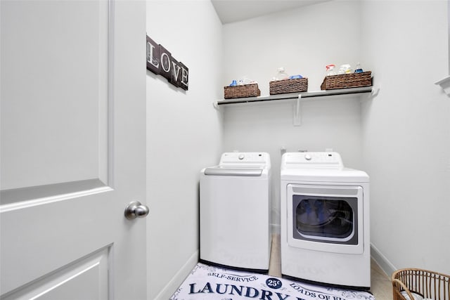 clothes washing area with laundry area, light tile patterned flooring, baseboards, and washing machine and clothes dryer