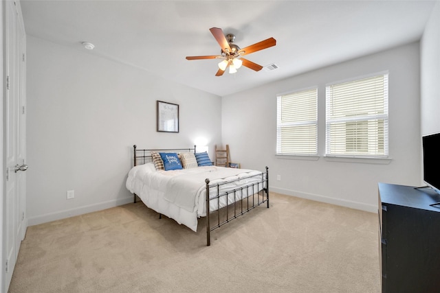 bedroom with visible vents, baseboards, light colored carpet, and ceiling fan