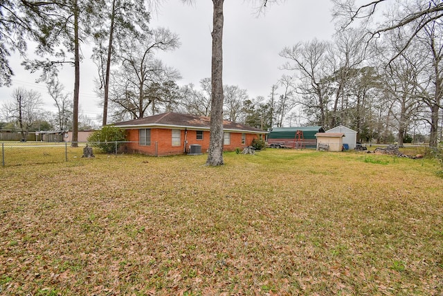 view of yard with central AC unit and fence