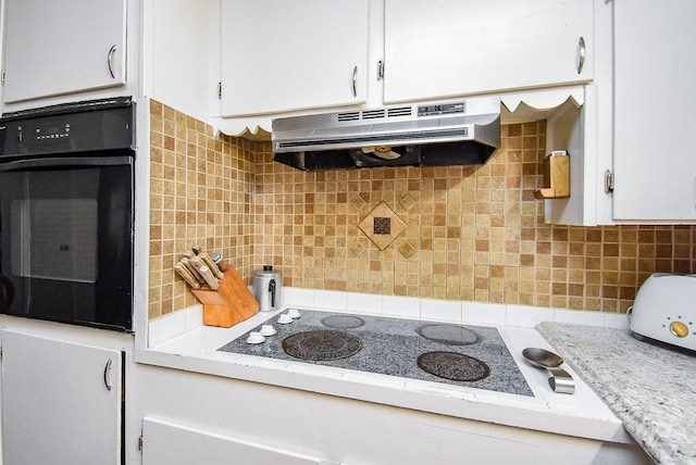 kitchen with light countertops, electric cooktop, white cabinetry, oven, and under cabinet range hood