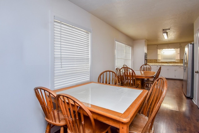 dining area with visible vents and dark wood finished floors