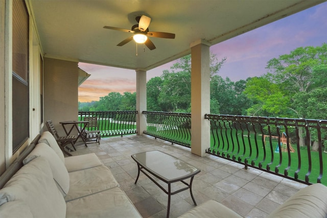 balcony at dusk with a sunroom and a ceiling fan