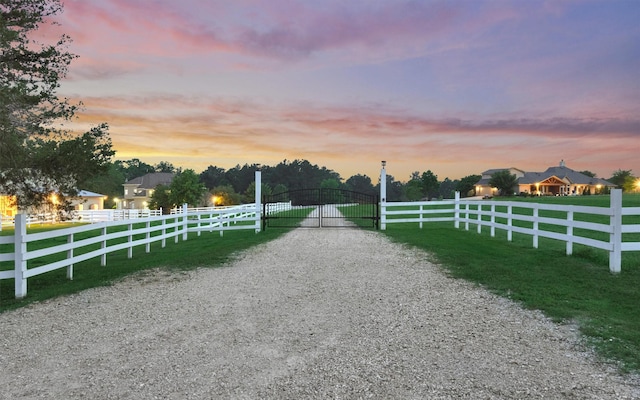 view of road featuring a gate, a rural view, driveway, and a gated entry