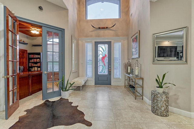 tiled foyer entrance with a high ceiling, french doors, visible vents, and baseboards