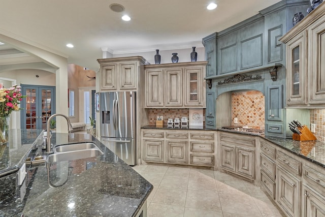 kitchen featuring stainless steel appliances, french doors, a sink, and decorative backsplash