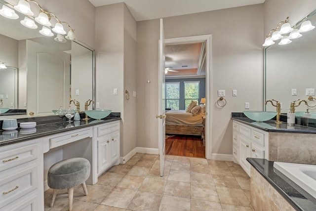 ensuite bathroom featuring a ceiling fan, vanity, ensuite bath, baseboards, and tile patterned floors