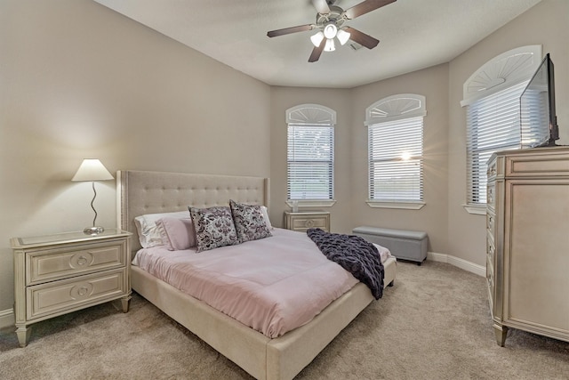 bedroom with light carpet, ceiling fan, and baseboards