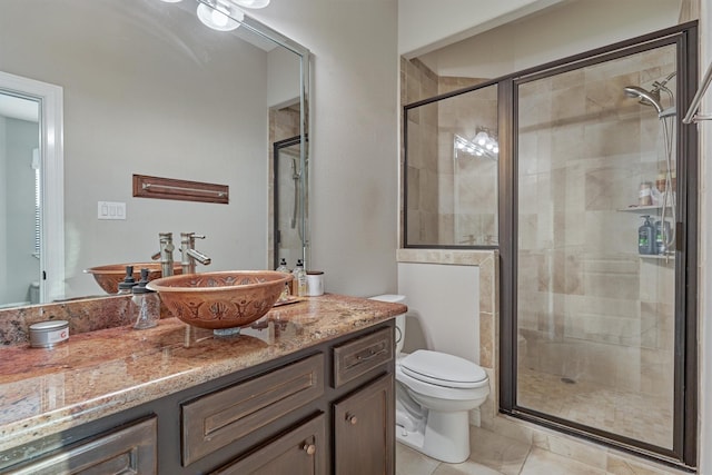 full bath with a stall shower, vanity, toilet, and tile patterned floors