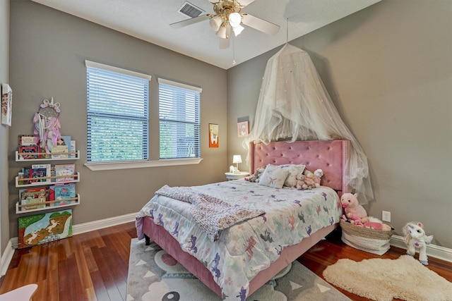 bedroom with baseboards, visible vents, ceiling fan, and wood finished floors