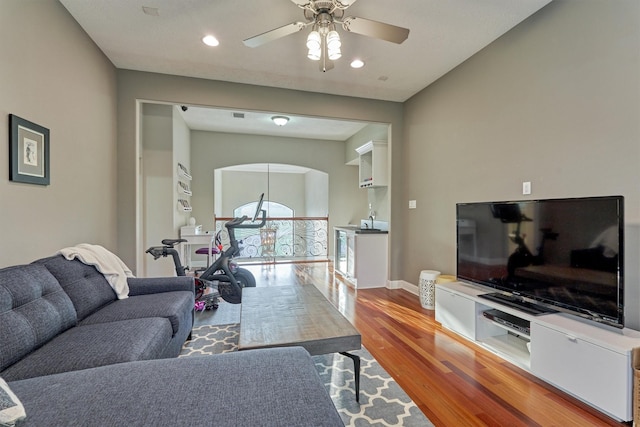 living area with recessed lighting, ceiling fan, baseboards, and wood finished floors