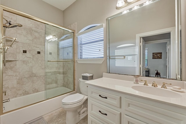 bathroom featuring tile patterned flooring, shower / bath combination with glass door, vanity, and toilet