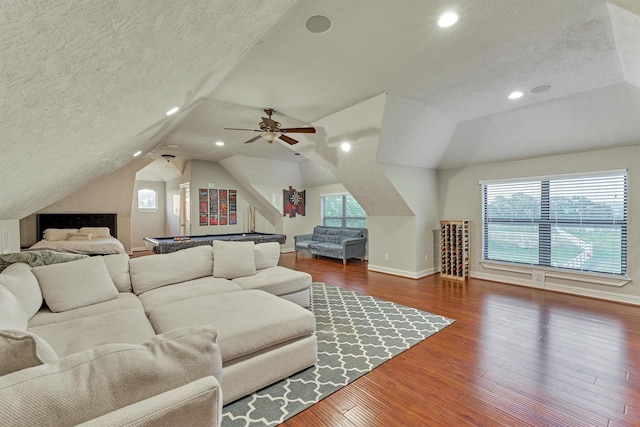 living room featuring a textured ceiling, lofted ceiling, recessed lighting, wood finished floors, and baseboards