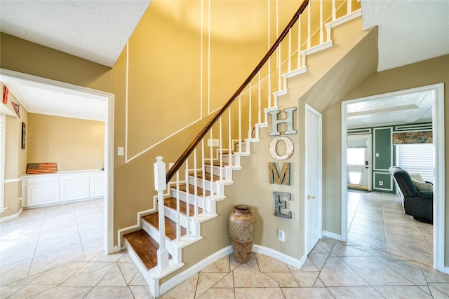 stairway with baseboards and tile patterned floors