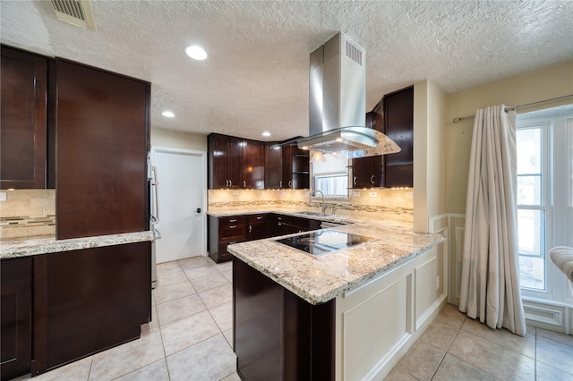 kitchen with light tile patterned floors, visible vents, light stone countertops, island exhaust hood, and black electric stovetop