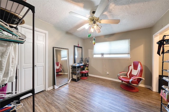 playroom featuring ceiling fan, a textured ceiling, baseboards, and wood finished floors