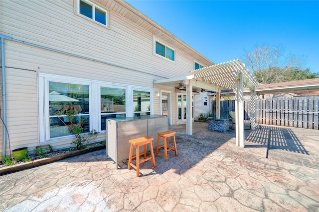 view of patio featuring fence, a ceiling fan, and a pergola