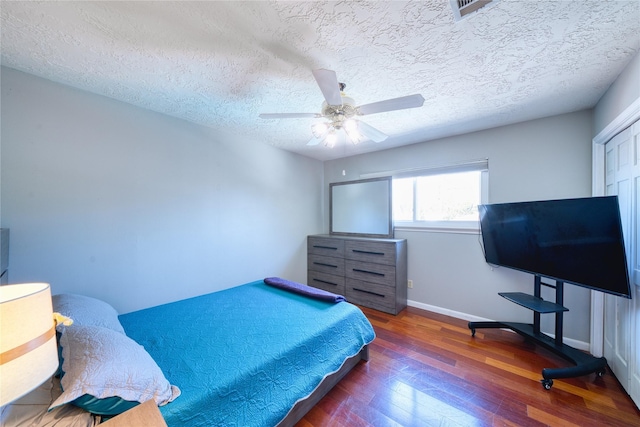 bedroom with ceiling fan, a textured ceiling, baseboards, and wood finished floors