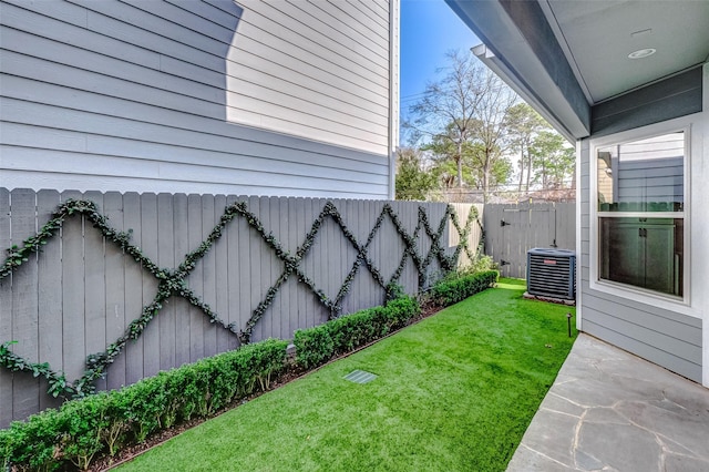 view of yard with central AC unit and fence