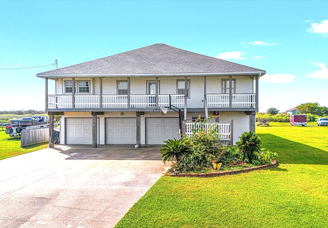 1907 103rd St, Galveston, TX 77554 - view of front of property featuring a garage, a shingled roof, concrete driveway, covered porch, and a front yard