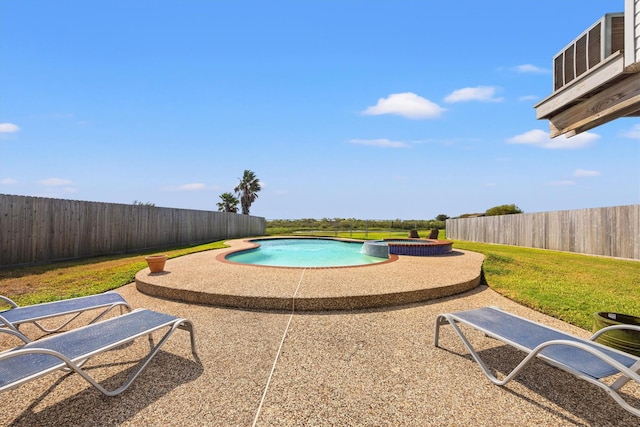 view of pool featuring a yard, a pool with connected hot tub, a fenced backyard, and a patio